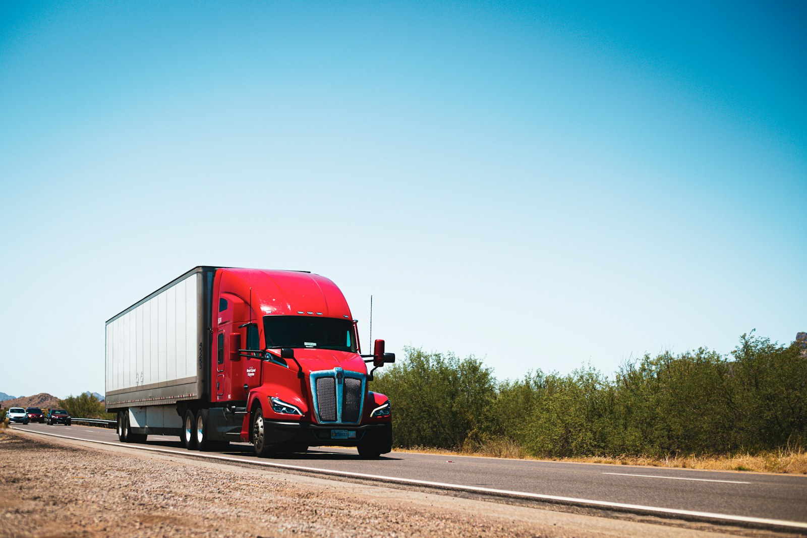 Red Class 8 semi-truck on a country road